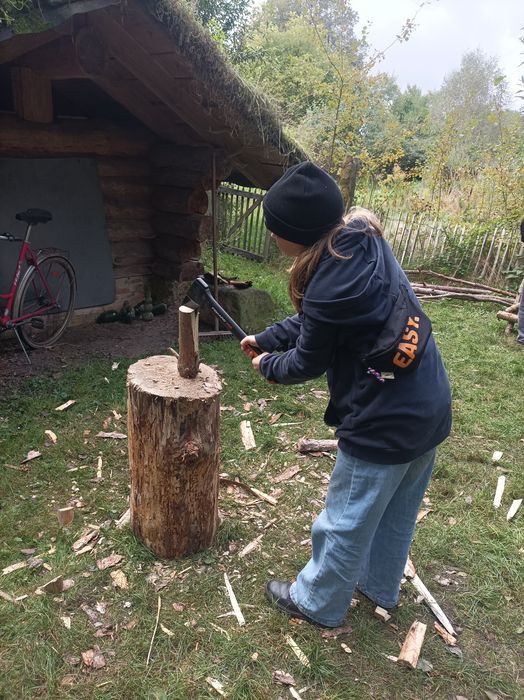 Junges Mädchen hackt Holz